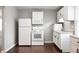 Cozy kitchen featuring white appliances, ample cabinetry, and dark, sleek floors at 3225 S Rybolt Ave, Indianapolis, IN 46221