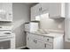 A well-lit kitchen with white appliances and cabinets with a double basin sink and faucet at 3225 S Rybolt Ave, Indianapolis, IN 46221