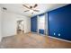 The living room has carpeted floors, a blue accent wall, a ceiling fan and a window at 3225 S Rybolt Ave, Indianapolis, IN 46221