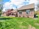 Spacious backyard with lush green lawn and a charming brick home with an inviting outdoor deck at 3559 Towne Dr, Carmel, IN 46032