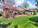 Lush backyard featuring a brick home with a cozy wooden deck and blooming trees at 3559 Towne Dr, Carmel, IN 46032