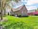 Spacious backyard with a lush green lawn and brick house, perfect for outdoor activities at 3559 Towne Dr, Carmel, IN 46032