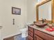 Powder room featuring a wood vessel sink on granite countertop, with warm wood cabinets and a bronze framed mirror at 3559 Towne Dr, Carmel, IN 46032