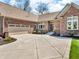 Paver driveway leading to a brick home with a two-car attached garage and manicured landscaping at 3559 Towne Dr, Carmel, IN 46032