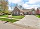 Charming brick home on a large lot featuring mature trees, lush lawn and a patterned concrete driveway at 3559 Towne Dr, Carmel, IN 46032