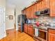 Functional kitchen includes stainless steel appliances, wooden cabinets, and granite countertops with hardwood flooring at 3559 Towne Dr, Carmel, IN 46032
