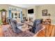 Comfortable living room with a fireplace, large windows, plush seating, and hardwood floors with decorative border at 3559 Towne Dr, Carmel, IN 46032