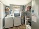 Practical laundry room with modern washer, dryer, storage shelves, and water heater at 3736 W South Wood Lake Dr, Columbus, IN 47201