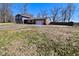 A view of the home from the backyard and driveway with a full yard and beautiful trees at 425 Conduitt Dr, Mooresville, IN 46158