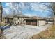 Rear view of the house featuring a two-car garage and gravel driveway with ample parking at 4709 S County Road 500 E, Plainfield, IN 46168