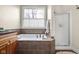 Bathroom featuring a soaking tub with brown tile, granite vanity, a walk-in shower, and large window at 4965 N 500 W, Columbus, IN 47201