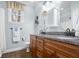 Bathroom features a granite countertop, dual sinks, wooden cabinets, and a window at 4965 N 500 W, Columbus, IN 47201
