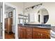 Double vanity bathroom with black granite counters, wood cabinets, and closet access at 4965 N 500 W, Columbus, IN 47201