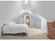 Attic bedroom featuring neutral carpet, dresser, and white door in a bright space at 4965 N 500 W, Columbus, IN 47201