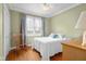 Bright bedroom featuring wood floors, a rocking chair, and a cozy bed with white comforter at 4965 N 500 W, Columbus, IN 47201