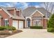 Close-up of the home's front exterior showcasing the brick and wood facade, two-car garage, and landscaped yard at 4965 N 500 W, Columbus, IN 47201