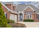 Close-up of the home's front exterior showcasing the brick and wood facade, two-car garage, and landscaped yard at 4965 N 500 W, Columbus, IN 47201