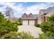 Exterior view of house featuring two-car garage, dormer windows, and basketball hoop, surrounded by lush greenery at 4965 N 500 W, Columbus, IN 47201