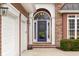 A welcoming front entrance features a blue door with glass panel and brick accents, enhanced by elegant lighting at 4965 N 500 W, Columbus, IN 47201