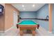 Finished basement game room featuring a pool table, blue brick accent wall and neutral carpeting at 4965 N 500 W, Columbus, IN 47201