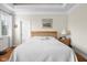 Comfortable bedroom features a bed with a white comforter, wood floors, and natural light from a window at 4965 N 500 W, Columbus, IN 47201