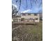 Backyard view of a two-story home with a wooden deck, mature trees, and green space at 5155 Overland Ct, Indianapolis, IN 46268