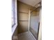 Shower stall with glass doors in a tiled bathroom featuring window and towel bars at 5155 Overland Ct, Indianapolis, IN 46268