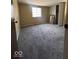 This carpeted bedroom has a closet, a window for natural light and tan painted walls at 5155 Overland Ct, Indianapolis, IN 46268