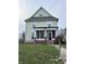 Charming two-story home with a front porch, offering a glimpse of a cozy living space at 550 Sutherland Ave, Indianapolis, IN 46205