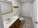 Functional bathroom featuring a wood vanity and standard toilet, with tile flooring and clean walls at 6232 Behner Xing, Indianapolis, IN 46250