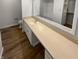 Bright bathroom featuring a long countertop, sink, and a large mirror reflecting a bathtub and closet at 6232 Behner Xing, Indianapolis, IN 46250