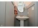 Cozy powder room showcasing a pedestal sink, decorative mirror, and charming wallpaper at 655 Bracknell Dr, Avon, IN 46123