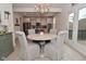 Bright dining area with a round table, chandelier, and an open view to the modern kitchen at 655 Bracknell Dr, Avon, IN 46123