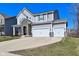 Charming two-story home boasts a large driveway and a two-car garage, complemented by stone accents and a well-maintained lawn at 655 Bracknell Dr, Avon, IN 46123