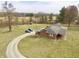 Aerial view of the charming brick home, outbuildings, and circular driveway on a lush, spacious lot at 6900 W Georgetown Rd, Columbus, IN 47201