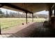 Covered back porch with wood floors, seating, and backyard views at 6900 W Georgetown Rd, Columbus, IN 47201