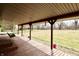 Covered back porch with wood floors, swing, and view of the spacious backyard at 6900 W Georgetown Rd, Columbus, IN 47201