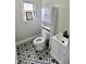 Compact bathroom featuring modern fixtures, gray and white geometric tile, and bright natural light at 6900 W Georgetown Rd, Columbus, IN 47201