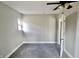 Cozy bedroom with neutral paint, carpet, ceiling fan, and open white door at 6900 W Georgetown Rd, Columbus, IN 47201