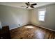Bedroom featuring hardwood floors, a ceiling fan, and a large window for natural light at 6900 W Georgetown Rd, Columbus, IN 47201