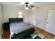 Cozy bedroom featuring a plush bed, hardwood flooring, and a ceiling fan at 6900 W Georgetown Rd, Columbus, IN 47201