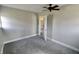 Small bedroom with plush carpet, ceiling fan, and an open white door at 6900 W Georgetown Rd, Columbus, IN 47201