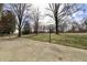 Exterior view of a concrete patio, basketball hoop, mature trees and a grassy area at 6900 W Georgetown Rd, Columbus, IN 47201