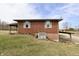 Brick home featuring a covered patio, green grass and well maintained lawn at 6900 W Georgetown Rd, Columbus, IN 47201