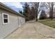 Exterior view of vinyl siding, a concrete patio, and a fenced-in yard with mature trees at 6900 W Georgetown Rd, Columbus, IN 47201