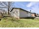 Exterior view with vinyl siding on a grassy lot, a satellite dish, white door and a glimpse of a red brick home at 6900 W Georgetown Rd, Columbus, IN 47201