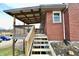 Brick home with back patio, wooden stairs and landscaping at 6900 W Georgetown Rd, Columbus, IN 47201