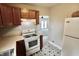 Galley-style kitchen with a range, white appliances, and patterned gray flooring at 6900 W Georgetown Rd, Columbus, IN 47201
