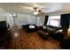 Spacious living room with lots of seating, ceiling fan and vinyl flooring at 6900 W Georgetown Rd, Columbus, IN 47201