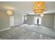 Open living room with modern lighting, new carpet and access to rear yard at 6900 W Georgetown Rd, Columbus, IN 47201
